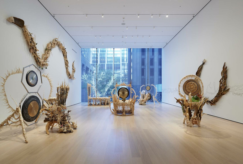 Installation view of the gallery "Guadalupe Maravilla: Luz y Fuerza" in the exhibition "Collection 1970s–Present,” October 30, 2021 - October 30, 2022. The Museum of Modern Art, New York. Digital Image ©️ 2022 The Museum of Modern Art, New York. Photo: David Almeida Image description: A photograph of seven sculptures made out of natural materials by the artist Guadalupe Maravilla, installed on the floor and the walls of a MoMA gallery.