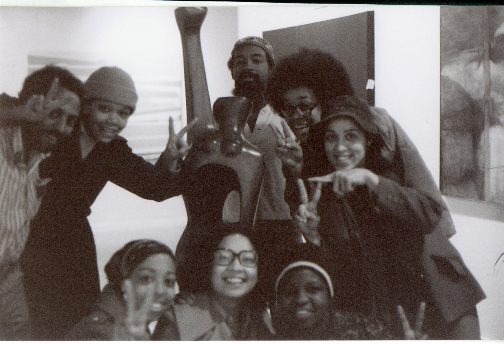 Clockwise from top left: Andy Owens, Linda Goode Bryant, David Hammons, Lowery Stokes Sims, Cheryl Mason Dorman, Faythe Weaver, Florence Harding, and Roberta Wolfe Bryant, with Elizabeth Catlett’s *Homage to My Young Black Sisters* (1968) before the opening of the exhibition Synthesis, Just Above Midtown, Fifty-Seventh Street, 1974. Courtesy Faythe Weaver, New York