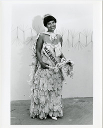 Lorraine O'Grady. Untitled (Mlle Bourgeoise Noir). 1980. Four gelatin silver prints, each: 10 × 8 in. (25.4 × 20.3 cm). Performed at the opening of Outlaw Aesthetics (1980). Maren Hassinger’s Palmettos (1980) is visible behind O’Grady in the image on the right. Maren Hassinger. Photographs by Freda Leinwand. Schlesinger Library, Harvard Radcliffe Institute