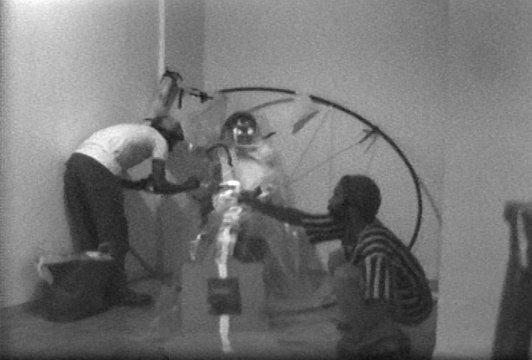 Still from video footage in the JAM Records featuring Randy Williams, Marquita Pool-Eckert, and David Hammons with Jorge Luis Rodriguez’s Circulo con cuatro esquinas (Circle with Four Corners) (1976), in Rodriguez’s exhibition Recent Sculpture, Just Above Midtown, Fifty-Seventh Street, 1976. Collection Linda Goode Bryant, New York