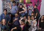 Open Art Space teens and teaching artists pose before a backdrop smiling at the camera. Photo: Néstor Pérez-Molière