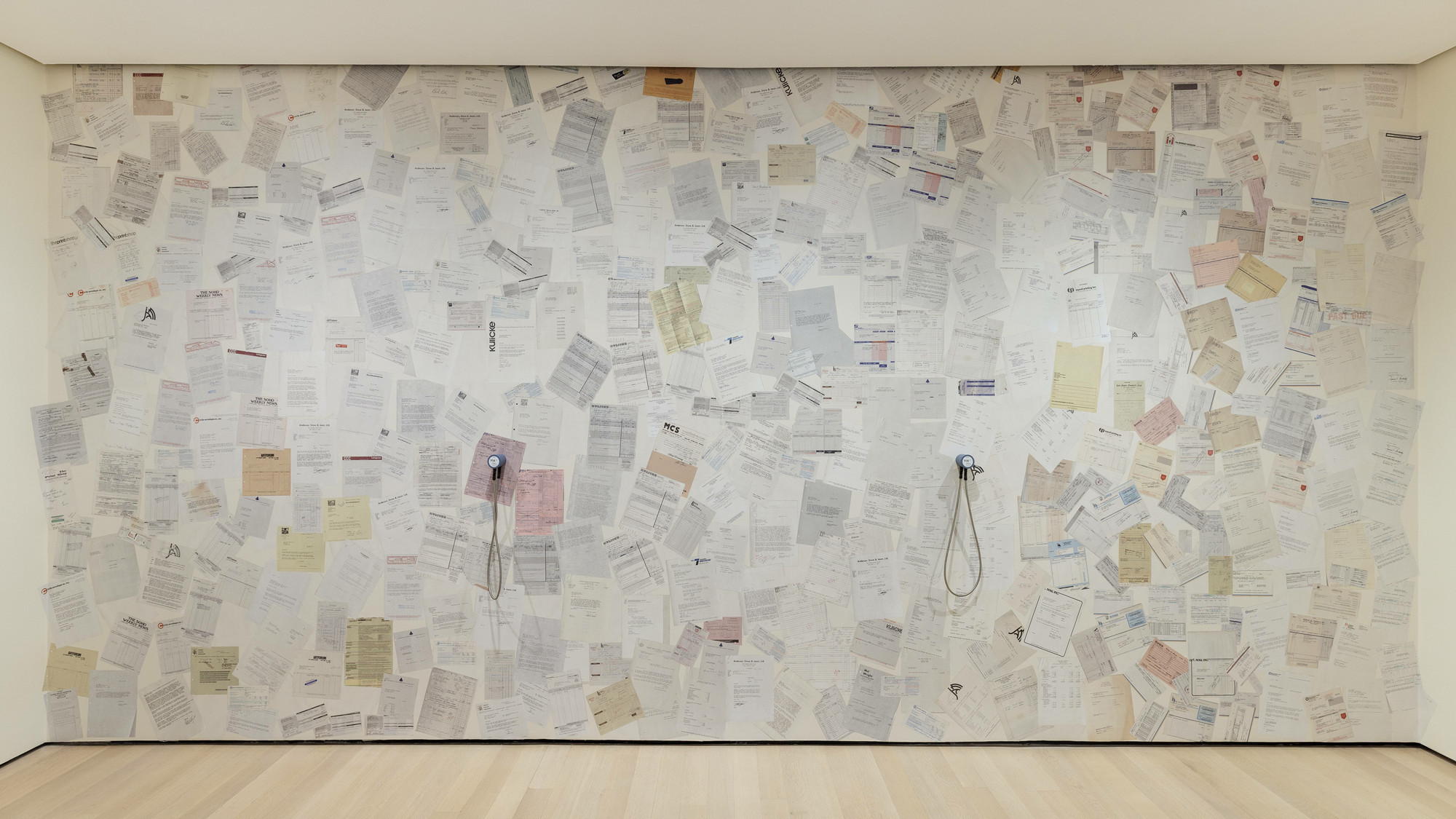 Installation view of wallpaper showing past-due bills issued to Just Above Midtown in the exhibition *Just Above Midtown: Changing Spaces* (September 10, 2022–February 18, 2023). Photograph by Emile Askey