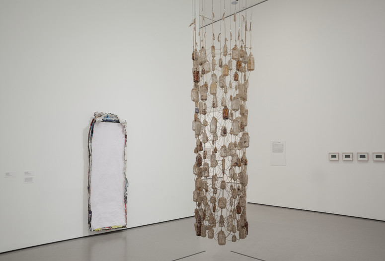 Installation view of Nari Ward&#39;s Vertical Hold. 1996. Yarn and bottles, 107 × 30&#34; (271.8 × 76.2 cm). The Museum of Modern Art, New York. Gift of the Hudgins Family in memory of J. I. Nelson and Sarita Nelson-Nunnelee Vertical Hold. 1996. Yarn and bottles, 107 × 30&#34; (271.8 × 76.2 cm). The Museum of Modern Art, New York. Gift of the Hudgins Family in memory of J. I. Nelson and Sarita Nelson-Nunnelee