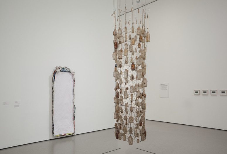 Installation view of Nari Ward's Vertical Hold. 1996. Yarn and bottles, 107 × 30" (271.8 × 76.2 cm). The Museum of Modern Art, New York. Gift of the Hudgins Family in memory of J. I. Nelson and Sarita Nelson-Nunnelee Vertical Hold. 1996. Yarn and bottles, 107 × 30" (271.8 × 76.2 cm). The Museum of Modern Art, New York. Gift of the Hudgins Family in memory of J. I. Nelson and Sarita Nelson-Nunnelee