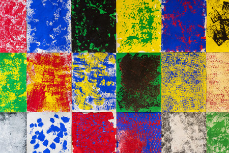 Photo: onwhitewall.com Image description: A close-up view of a colorful collaborative mural made of abstract paintings. Bright splatters and strokes of red, blue, green, and yellow paint overlap on vertically oriented pieces of white paper installed together in a grid formation.