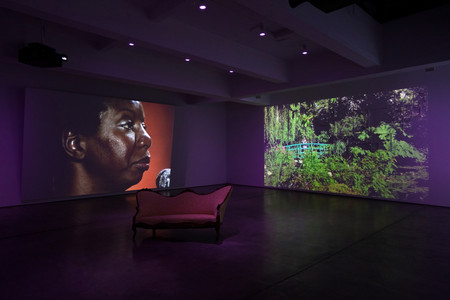 Ja’Tovia Gary. THE GIVERNY SUITE. 2019. Three-channel high-definition video and 16mm film transferred to high-definition video (black and white and color, stereo sound; 39:51 min.); settee; 25 painted frames; altar to Yemaya (candle, seashells, anchor, fruit, plate, vase, flowers, glass jar of molasses, glass jar of rum, and fabric); and altar to Oshun (candle, mirror, cowrie shells, fruit, cinnamon sticks, plate, vases, flowers, glass jar of white wine, glass jar of honey, and fabric), overall dimensions variable. The Museum of Modern Art, New York. Fund for the Twenty-First Century
