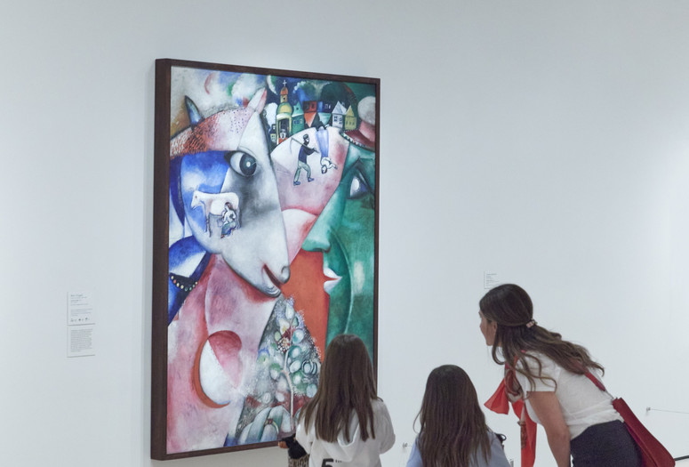 Image: Marc Chagall. I and the Village. 1911. Oil on canvas. The Museum of Modern Art, New York. Mrs. Simon Guggenheim Fund. © 2023 Artists Rights Society (ARS), New York/ADAGP, Paris Image description: A family talks about what they notice in the painting I and the Village by Marc Chagall