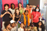 Photo: Ébun Nazon-Power Image description: Open Art Space teens and teaching artists pose before a backdrop smiling at the camera.