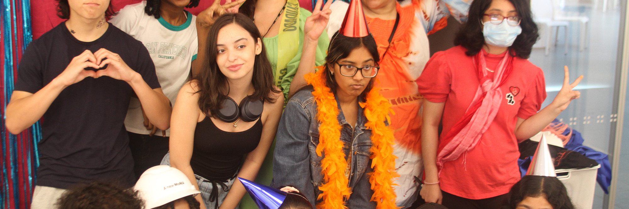 Photo: Ébun Nazon-Power Image description: Open Art Space teens and teaching artists pose before a backdrop smiling at the camera.