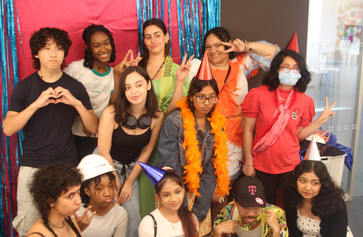 Photo: Ébun Nazon-Power Image description: Open Art Space teens and teaching artists pose before a backdrop smiling at the camera.