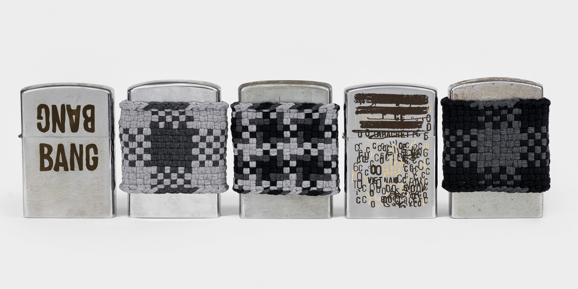 An-My Lê. đô-mi-nô (detail). 2021 Vintage novelty lighters and cotton yarn, each 6 1/2 × 4 1/4 × 1 1/2" (16.5 × 10.8 × 3.8 cm), installation dimensions variable. © 2023 An-My Lê. Courtesy the artist and Marian Goodman Gallery