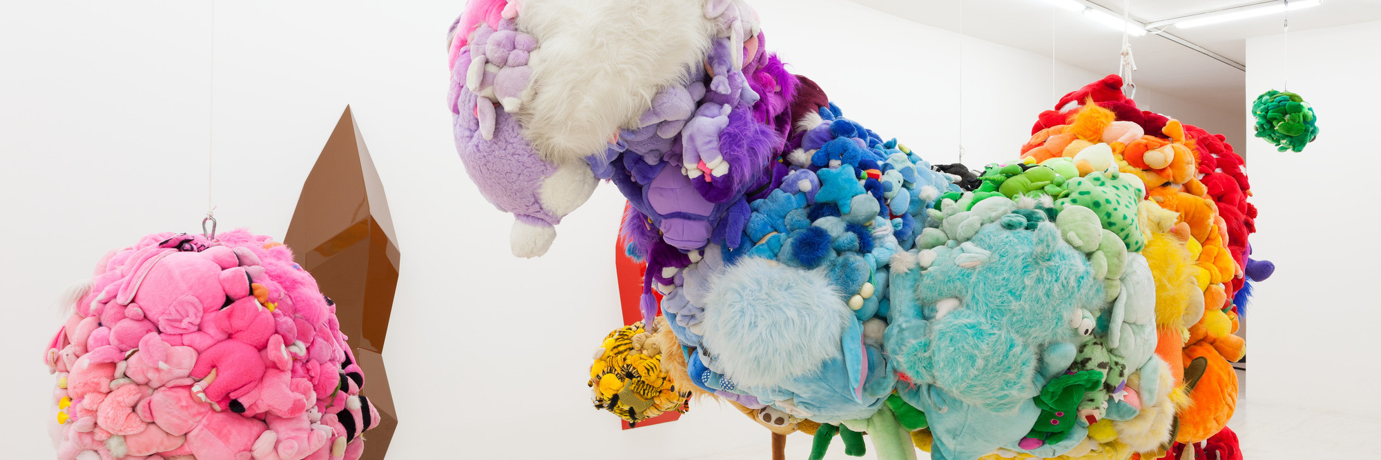 Mike Kelley. Deodorized Central Mass with Satellites. 1991/1999. Plush toys sewn over wood and wire frames with styrofoam packing material, nylon rope, pulleys, steel hardware and hanging plates, fiberglass, car paint, and disinfectant; overall dimensions variable. The Museum of Modern Art, New York. Partial gift of Peter M. Brant, courtesy the Brant Foundation, Inc. and gift of The Sidney and Harriet Janis Collection (by exchange), Mary Sisler Bequest (by exchange), Mr. and Mrs. Eli Wallach (by exchange), The Jill and Peter Kraus Endowed Fund for Contemporary Acquisitions, Anne and Joel Ehrenkranz, Mimi Haas, Ninah and Michael Lynne, and Maja Oeri and Hans Bodenmann