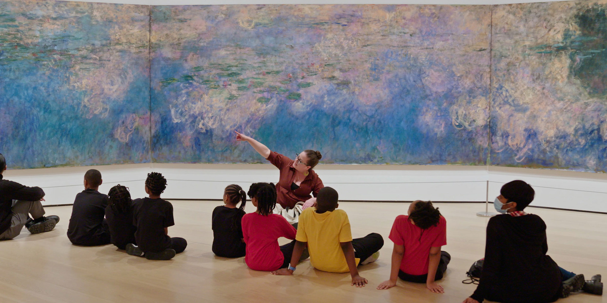 A still from the video Art as a Tool for Social and Emotional Learning. © 2024 The Museum of Modern Art, New York. Shown: Claude Monet. Water Lilies. 1914–26. Oil on canvas, three panels, each 6' 6 3/4" × 13' 11 1/4" (200 × 424.8 cm), overall 6' 6 3/4" × 41' 10 3/8" (200 × 1276 cm). The Museum of Modern Art, New York. Mrs. Simon Guggenheim Fund