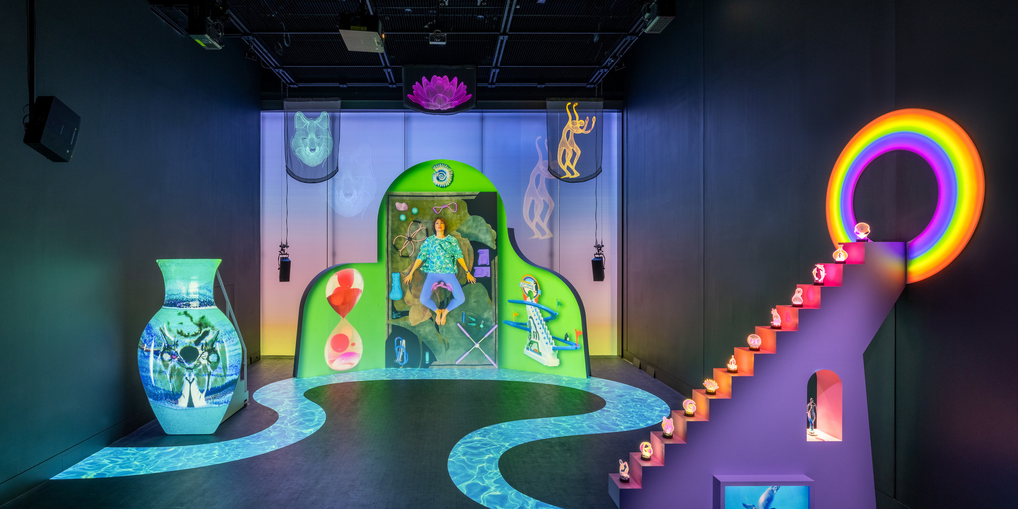 Shana Moulton. Meta/Physical Therapy. 2023–24. Eight-channel 4K and high-definition video (color, sound; 14:49 min.), MDF, vinyl, seating, scrims, props, and window gel, dimensions variable. Courtesy the artist, Galerie Crèvecœur, and Galerie Gregor Staiger. © 2024 Shana Moulton. Installation view, on view at The Museum of Modern Art from February 17, 2024 – April 21, 2024. Photo: Jonathan Dorado