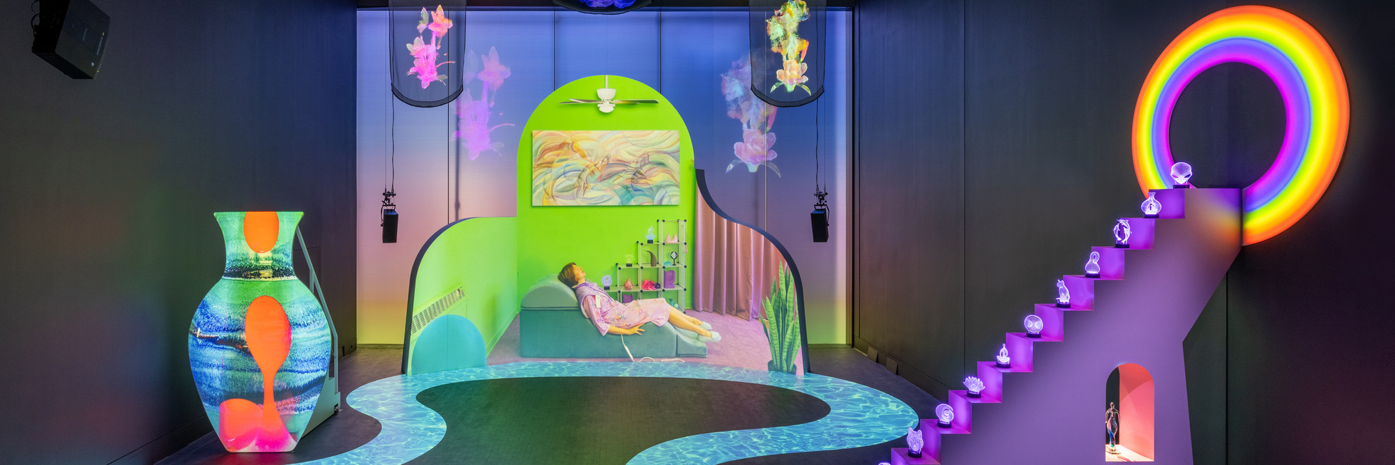 Shana Moulton. Meta/Physical Therapy. 2023–24. Eight-channel 4K and high-definition video (color, sound; 14:49 min.), MDF, vinyl, seating, scrims, props, and window gel, dimensions variable. Courtesy the artist, Galerie Crèvecœur, and Galerie Gregor Staiger. ©️ 2024 Shana Moulton. Installation view, The Museum of Modern Art, New York, February 17–April 21, 2024. Photo: Jonathan Dorado