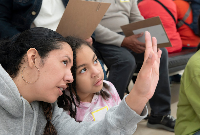 Photo: Martin SeckImage description: A caregiver explains something to the child beside them.