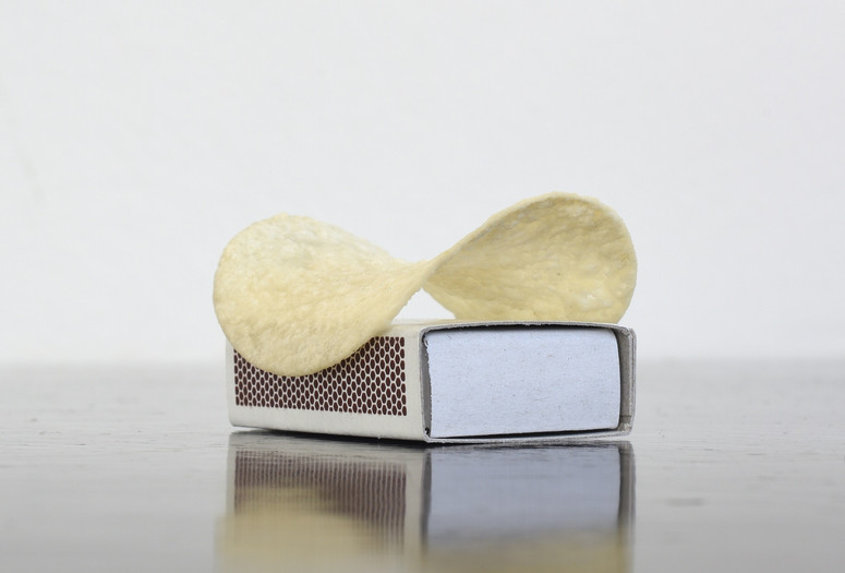 Thomas Schütte. Pringles. 2011. Pringles chip and matchbox. Collection of the artist, Düsseldorf. Photo: Luise Heuter. ©️ 2024 Thomas Schütte/Artists Rights Society (ARS), New York/VG Bild-Kunst, BonnImage description: A sculpture made of a Pringles brand swoop-shaped potato chip sitting on top of a rectangular matchbox