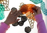 Photo: Martin SeckImage description: A child plays with materials on top of a lightbox.