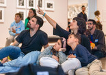 Photo: On White WallImage description: A caregiver points to an artwork while the rest of the family observes.