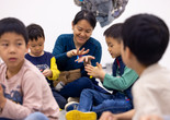 Photo: On White Wall Inc.Image description: Children and a caregiver play with model magic on the gallery floor