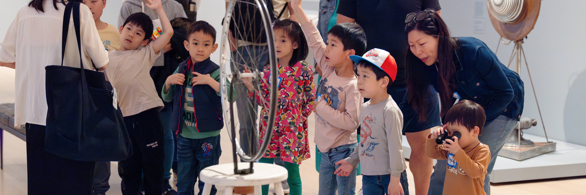 Photo: On White Wall Inc.Image description: An educator leads families in a discussion during a Family Art Adventures in Mandarin session.