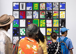 A group of visitors gather in front of a colorful artwork installation during an access exhibition opening at MoMA. Photo: onwhitewall.com. © 2025 The Museum of Modern Art, New York