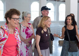 Credit: Beatriz Meseguer Image Description: A group of five older adults standing in an art gallery, smiling with each other.