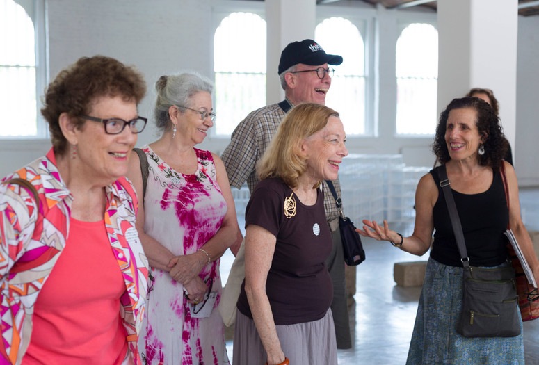 Credit: Beatriz Meseguer Image Description: A group of five older adults standing in an art gallery, smiling with each other.