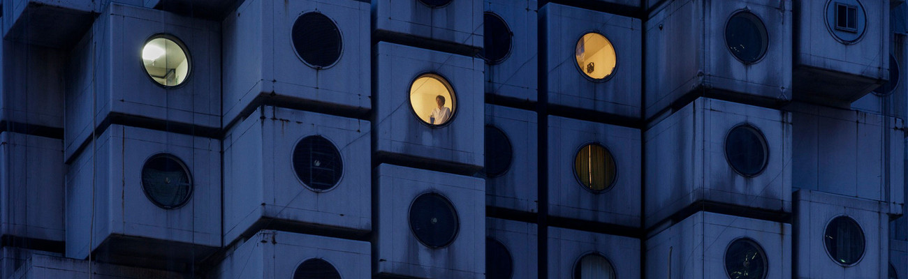 Night time at the Nakagin Capsule Tower, with Mr. Takayuki Sekine seen through the window of capsule B1004, 2016. © Jeremie Souteyrat
