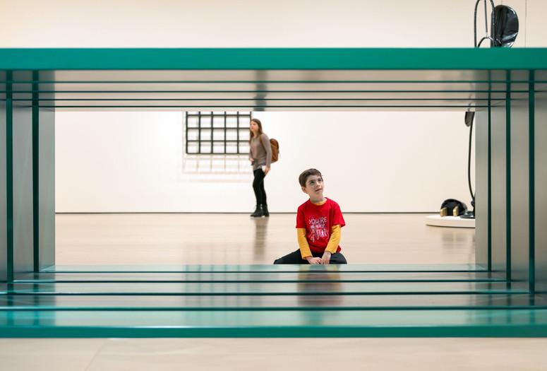 A child sits looking at Donald Judd’s untitled green, rectangular sculpture. Photo: On White Wall, Inc.