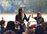 An educator leads a discussion in front of an artwork as two young children raise their hands. Photo: On White Wall, Inc.
