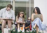 A seated family of three sketches in MoMA’s Sculpture Garden during a UNIQLO Family Day. Photo: Austin Donohue
