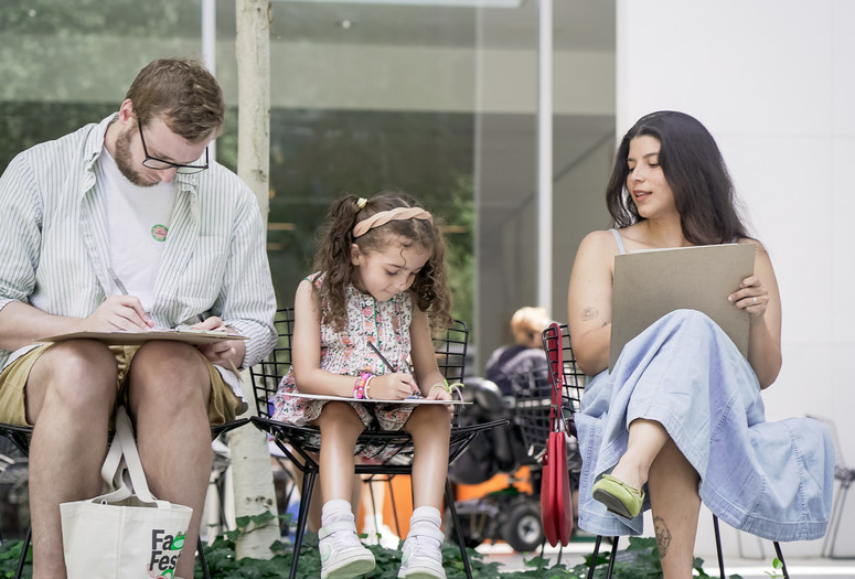 A seated family of three sketches in MoMA’s Sculpture Garden during a UNIQLO Family Day. Photo: Austin Donohue