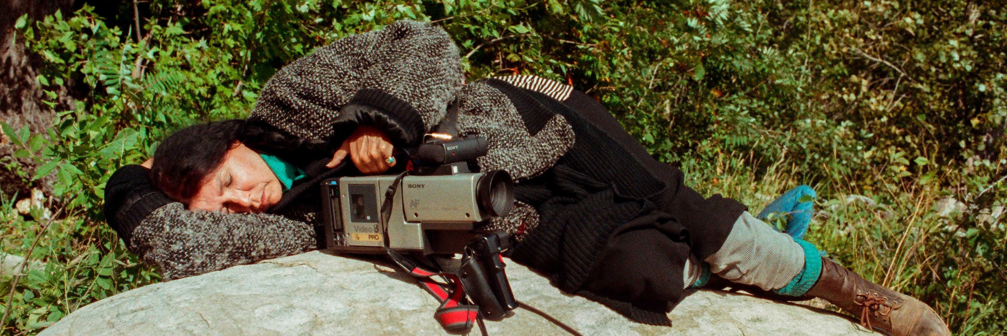 Alanis Obomsawin rests on a rock beside the Lake of Two Mountains, Kanehsatake, 1990. Photo: John Kenney