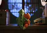 Lost and Found. 2018. Australia. Directed by Andrew Goldsmith, Bradley Slabe. Image courtesy Gerald Thompson. Image description: A knitted dinosaur and fox sit together on a counter, the dinosaur’s arm around the fox, gazing at a softly lit, round window.