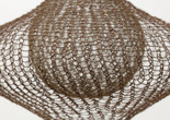 Ruth Asawa. Untitled (S.398, Hanging Eight-Lobed, Four-Part, Discontinuous Surface Form within a Form with Spheres in the Seventh and Eighth Lobes). 1955. Brass, galvanized steel, and steel wire. The Museum of Modern Art, New York. Promised gift of Alice and Tom Tisch. © Estate of Ruth Asawa. Image description: A wire sculpture with a net-like pattern creates a bulbous shape. The metal wire is predominantly brown against a light background.