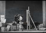 Uka. 2016. Spain. Directed by Valle Comba Canales. Courtesy of Cítrico Studio SLU. Image description: A black-and-white image of a little girl standing at a canvas with a paintbrush in her hand