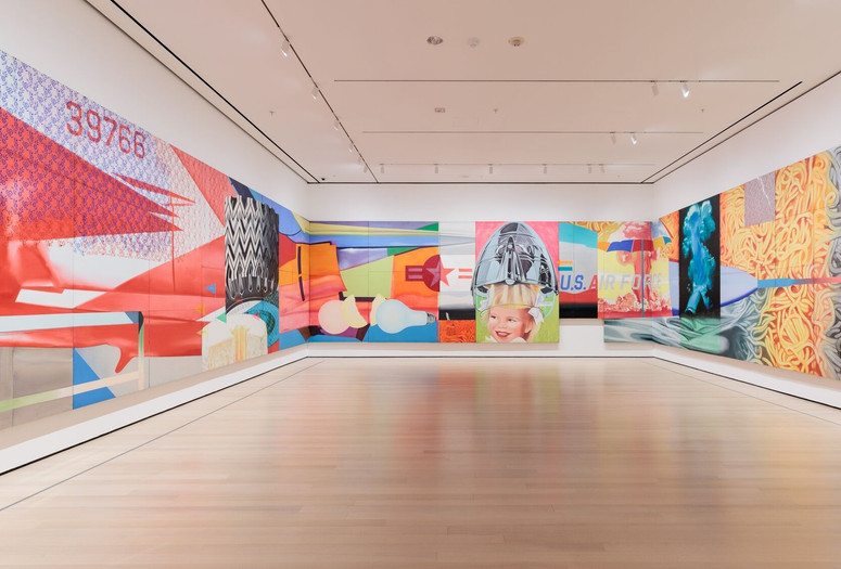 James Rosenquist. F-111. 1964–65. Oil on canvas with aluminum, 23 sections. The Museum of Modern Art New York. Gift of Mr. and Mrs. Alex L. Hillman and Lillie P. Bliss Bequest (both by exchange). © 2025 James Rosenquist/Licensed by VAGA, New York, NY. Installation view, photographed in October 2022. Photo: Emile Askey. Digital Image © 2025 The Museum of Modern Art, New York. Image description: A long, brightly colored painting hangs across three walls in a gallery.