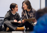 A mother and child look at each other and smile while doing an activity during a Family Gallery Talk. Photo: On White Wall, Inc.