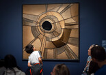 During a Family Gallery Talk, a child examines an artwork made of many pieces of brown fabric with a hole in the center. Artwork: Lee Bontecou. Untitled. 1959. Welded steel, canvas, black fabric, soot, and wire. The Museum of Modern Art, New York. Gift of Mr. and Mrs. Arnold H. Maremont. © 2026 Lee Bontecou. Photo: On White Wall, Inc.
