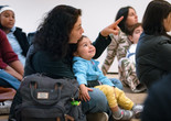 An adult points to an artwork as their child looks on during Arte en Familia. Photo: On White Wall, Inc.
