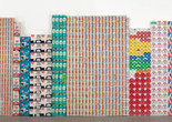 An artwork made with stacked empty containers and packaging is displayed in a gallery. Shown: George Maciunas. One Year. 1973–74. Various empty containers and packaging. Publisher: Fluxus. The Museum of Modern Art, New York. The Gilbert and Lila Silverman Fluxus Collection Gift. © 2026 George Maciunas. Used by permission