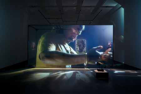 Christopher Kulendran Thomas. Being Human. 2019. High-definition video (color, sound; 24 min.) projected on glass, with three paintings and three sculptures: Untitled II, Untitled V, and Untitled VI (2018) by Upali Ananda, and Untitled II and Untitled V (2018) by Kingsley Gunatillake (all purchased by the artist from Saskia Fernando Gallery, Colombo); and Untitled X after Kingsley Gunatillake (2019) by Christopher Kulendran Thomas. In collaboration with Annika Kuhlmann. The Museum of Modern Art, New York. Acquired through the generosity of Charles Asprey and Markus Hannebauer, 2021. © Christopher Kuelndran Thomas