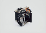 Christopher Williams. Cutaway model Nikon EM. 2008. Shutter: Electronically governed Seiko metal blade shutter vertical travel with speeds from 1/1000 to 1 second with a manual speed of 1/90th; meter: Center-weighted Silicon Photo Diode, ASA 25-1600, EV2-18 (with ASA film and 1.8 lens), Aperture Priority automatic exposure; lens mount: Nikon F mount, AI coupling, (and later) only; flash: Synchronization at 1/90 via hot shoe, Flash automation with Nikon SB-E or SB-10 flash units; focusing: K type focusing screen, not user interchangeable, with 3mm diagonal split image rangefinder; batteries: Two PX-76 or equivalent, 5.3 × 3.38 × 2.13" (135 × 86 × 54 mm). Photography by the Douglas M. Parker Studio, Glendale, California, September 9, 2007–September 13, 2007. Chromogenic print. The Museum of Modern Art, New York. Acquired through the generosity of Helen Kornblum in honor of Roxana Marcoci and Committee on Photography Fund. © 2026 Christopher Williams