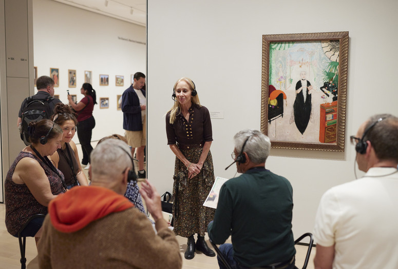 An educator speaks with a group of participants in front of a painting during Meet Me at MoMA. Photo: Jason Lindberg