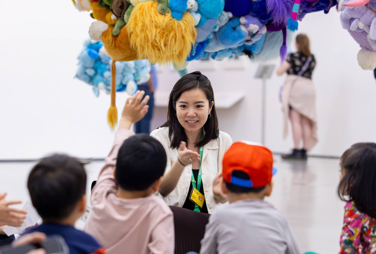 An educator teaches families in a gallery featuring large sculptures made of stuffed animals. Photo: On White Wall, Inc.
