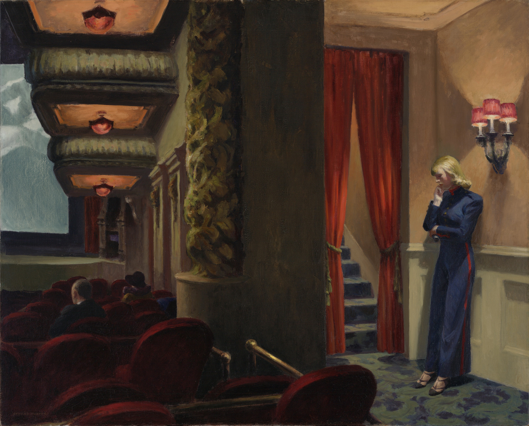 A dimly lit theater with red velvet seats and ornate decorations; a person in a dark blue uniform stands thoughtfully near red curtains beside a staircase. Predominant colors are red, blue, and beige. This is an AI generated description. To give feedback, email ai@moma.org.