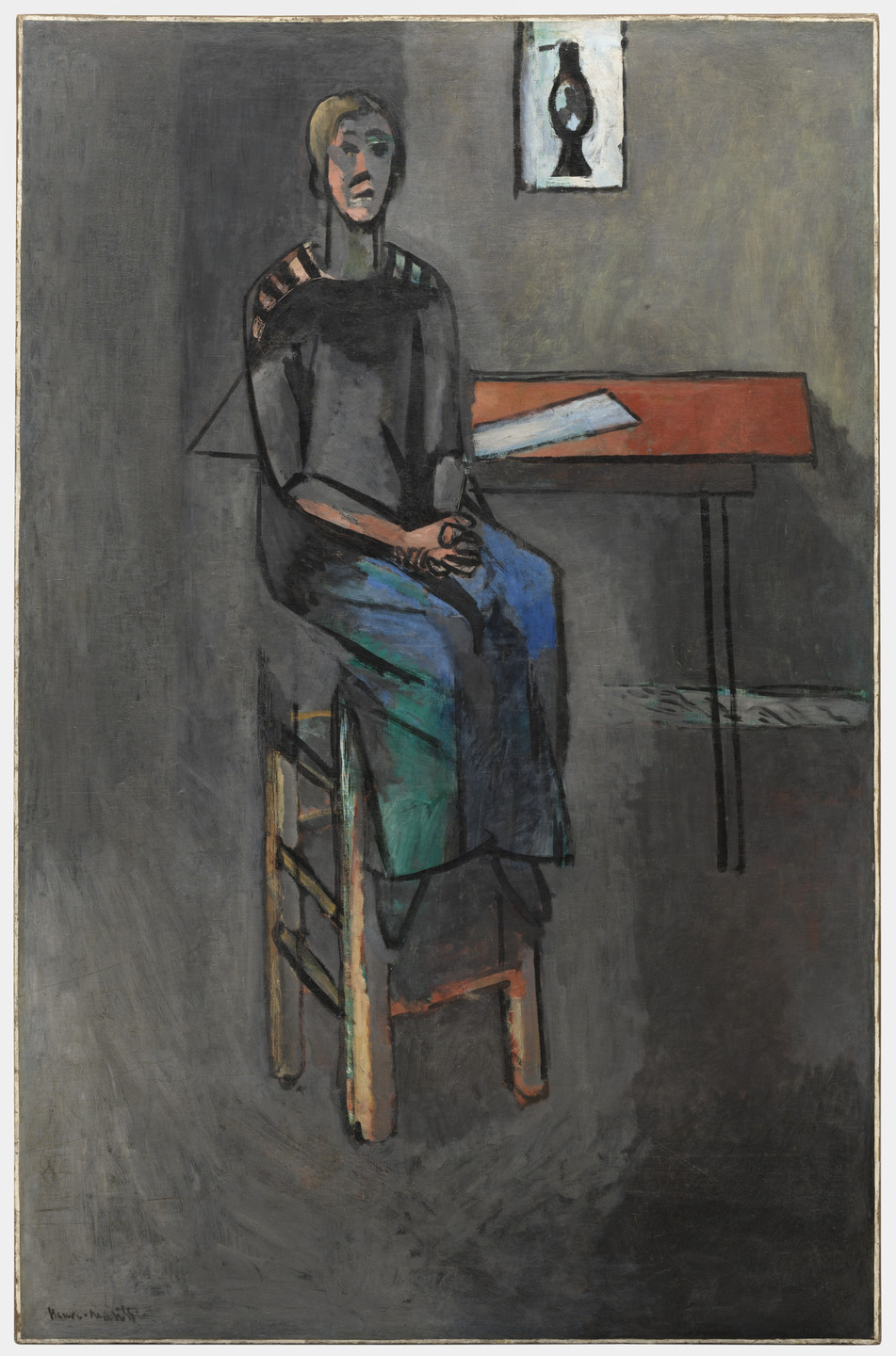 A person in dark clothing sits on a wooden chair next to a rectangular red table with a piece of paper on it. The background is mostly gray, and there is a framed image of a bird on the wall behind. This is an AI generated description. To give feedback, email ai@moma.org.