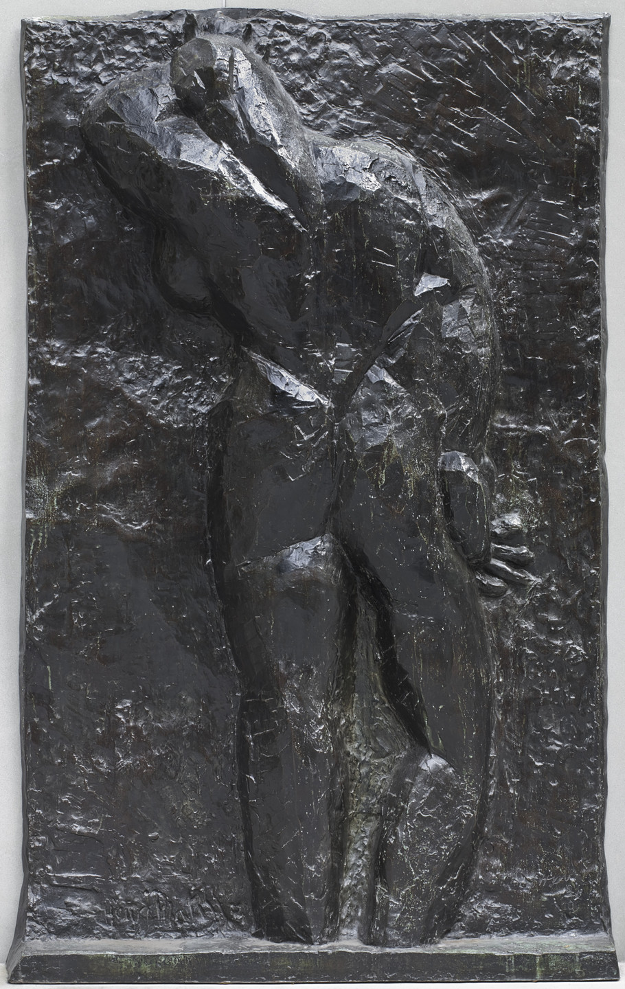 The image depicts a dark bronze relief sculpture of a standing figure with one hand on their chest and the other on their side. The background is heavily textured, also in dark bronze. This is an AI generated description. To give feedback, email ai@moma.org.