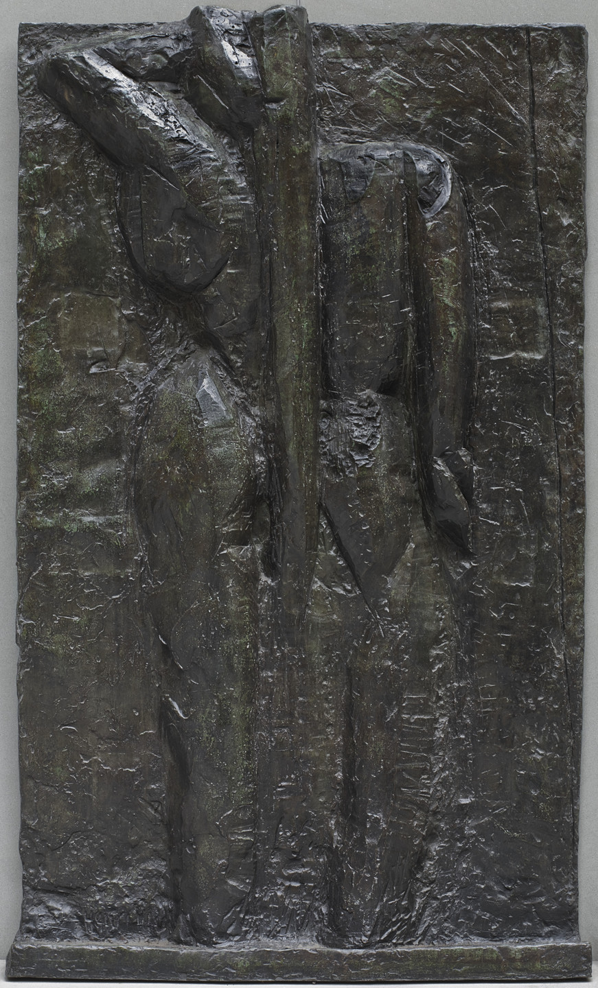 The image shows a relief sculpture with dark, textured surfaces and irregular shapes, predominantly in shades of dark brown and black, with hints of green. The surface appears rough and uneven. This is an AI generated description. To give feedback, email ai@moma.org.